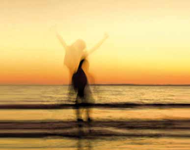 Frau am Meer bei Sonnenuntergang